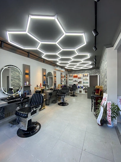 Efe Ateş Hair Design lüks salon iç mekanı, modern berber koltukları ve altın detaylı aynalar